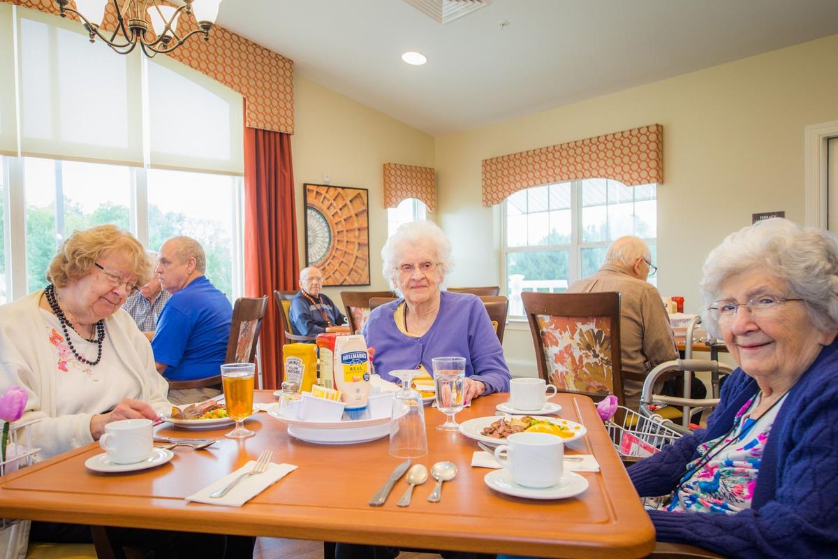 Elderly individuals enjoying a meal together in a community dining setting.