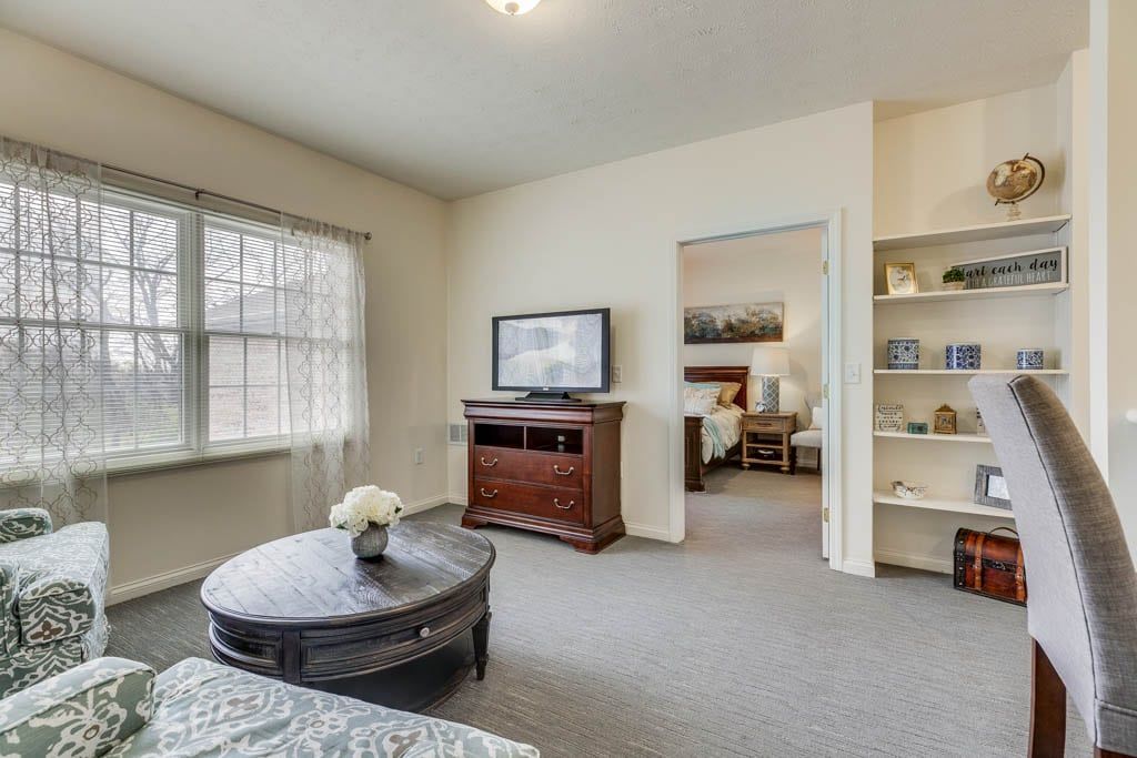 A cozy living room with a television, wooden furniture, and a comfortable atmosphere.