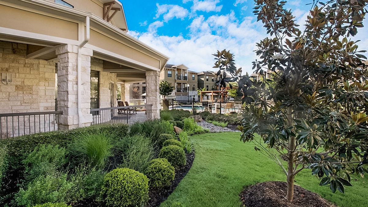 A beautiful home with a well-manicured garden and a spacious porch overlooking the greenery.