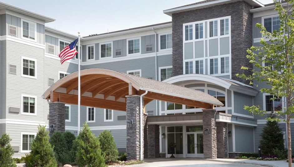 A modern building entrance with an American flag prominently displayed.