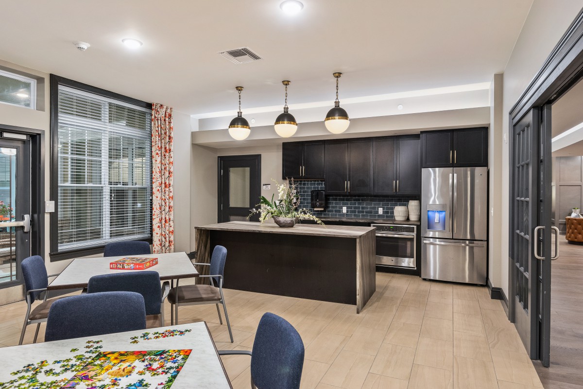 A modern kitchen with a dining area, featuring sleek appliances and stylish lighting.