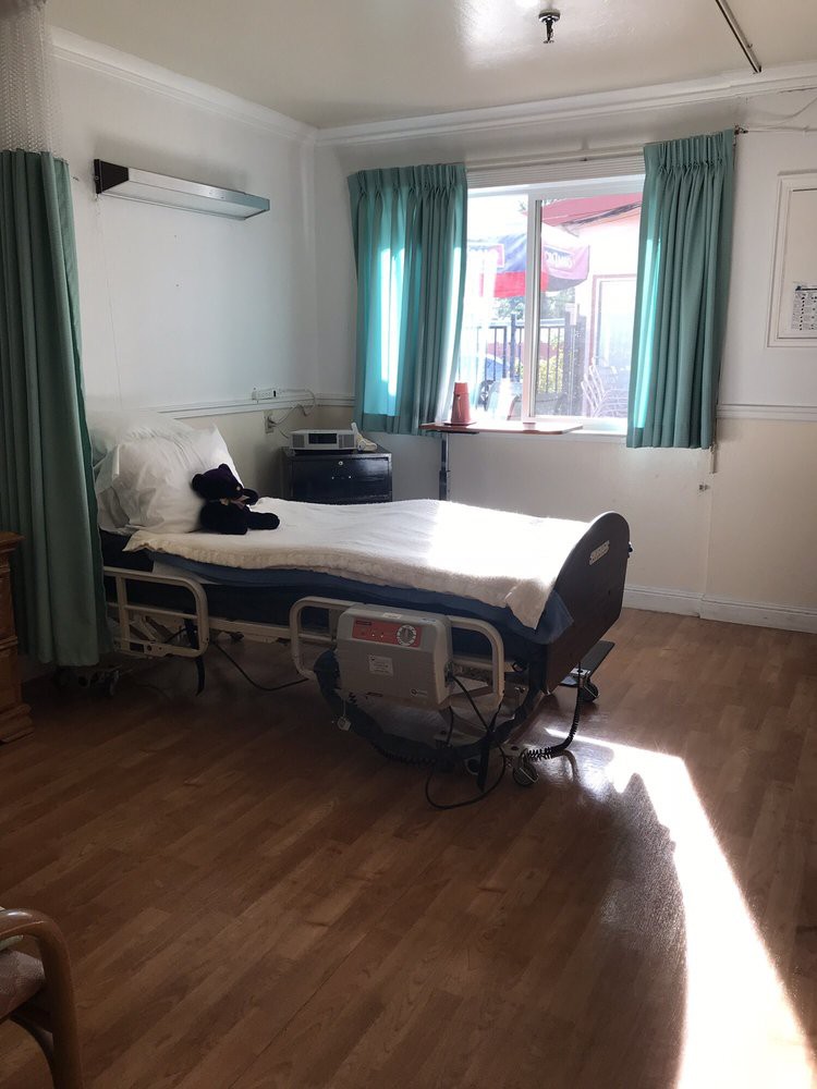 A hospital room with a bed near the window, sunlight streaming in.