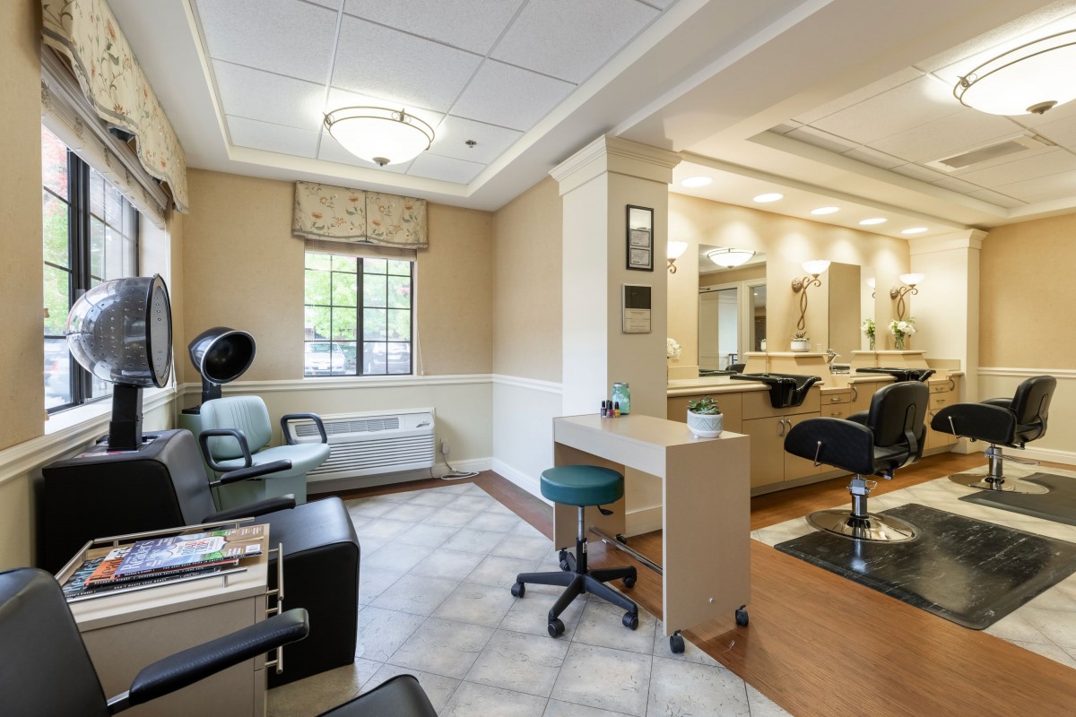 A modern and clean salon interior with styling chairs and mirrors.