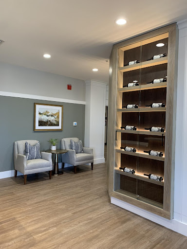 A modern waiting area featuring comfortable seating and a decorative display shelf.