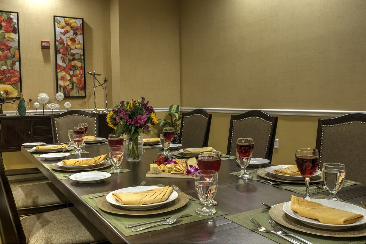 A beautifully set dining table with elegant decor and a centerpiece of flowers.