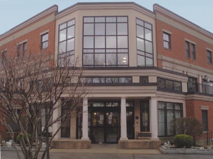 A modern commercial building featuring large windows and a classic brick facade.