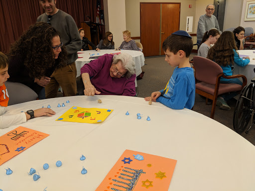 A lively family gathering where children and adults engage in a fun, interactive game at a community event.