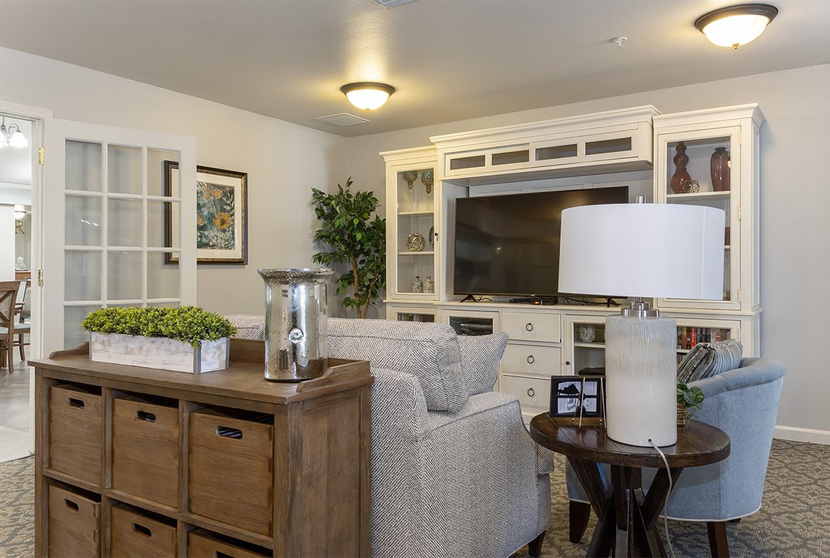 A cozy living room featuring a white TV cabinet, a comfortable sofa, and stylish decor elements.