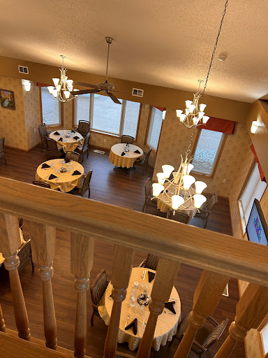 A cozy and elegant dining area with a view, complete with chandeliers and neatly set tables.