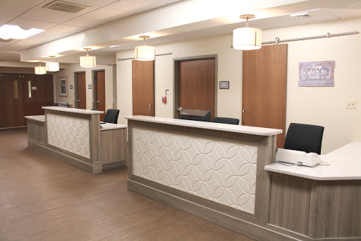 A modern reception area in a healthcare setting, featuring multiple desks and an inviting atmosphere.
