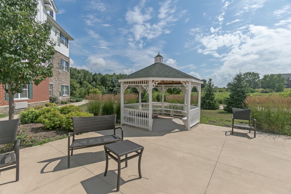A sunny outdoor patio with a white gazebo and seating area.