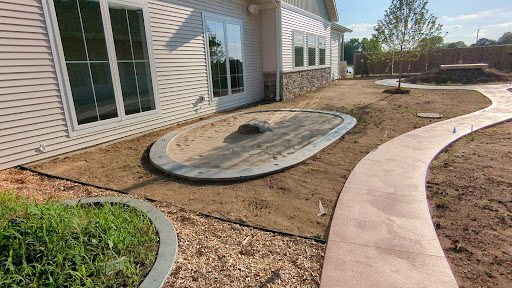 A newly prepared outdoor space with a partially completed patio area featuring a stone outline.