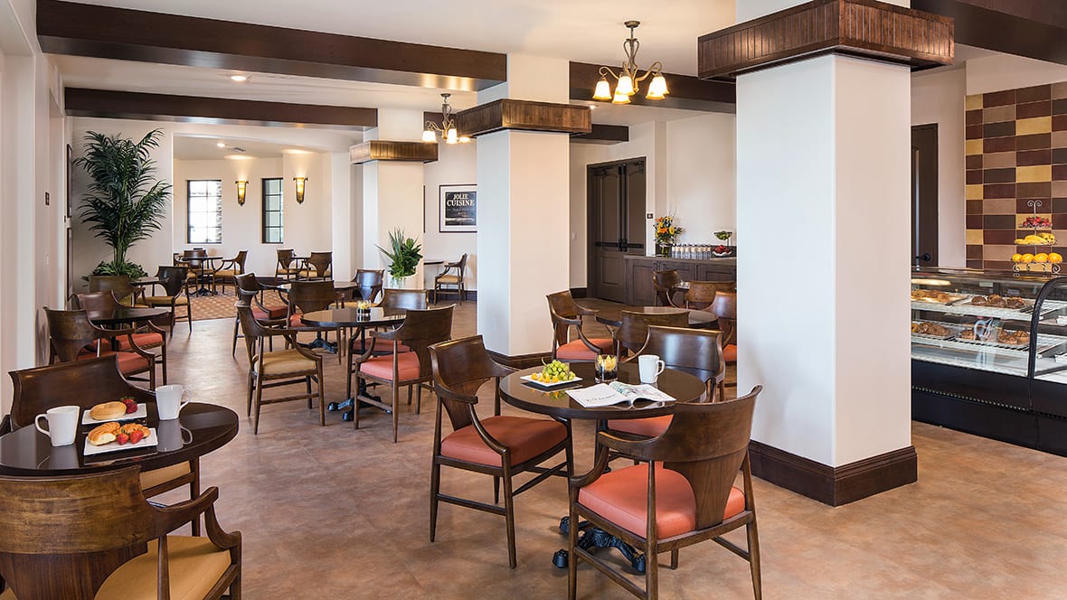 A cozy restaurant dining area with neatly arranged tables and chairs, featuring elegant lighting and inviting decor.