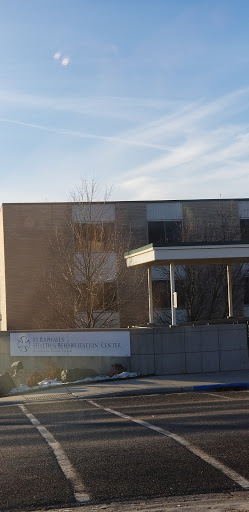 A modern building surrounded by trees on a clear day.