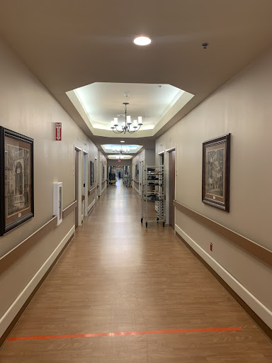 A well-lit interior hallway featuring decorative frames on the walls.