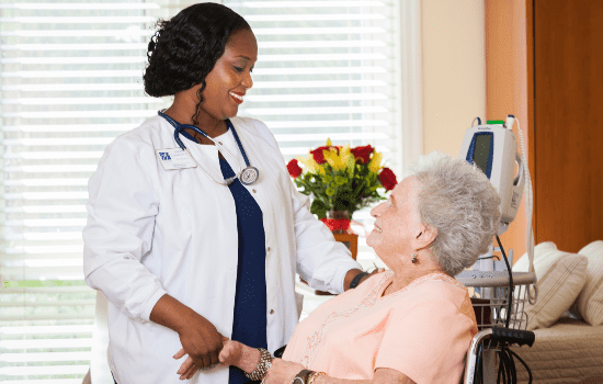 A nurse interacting with an elderly woman in a medical setting.