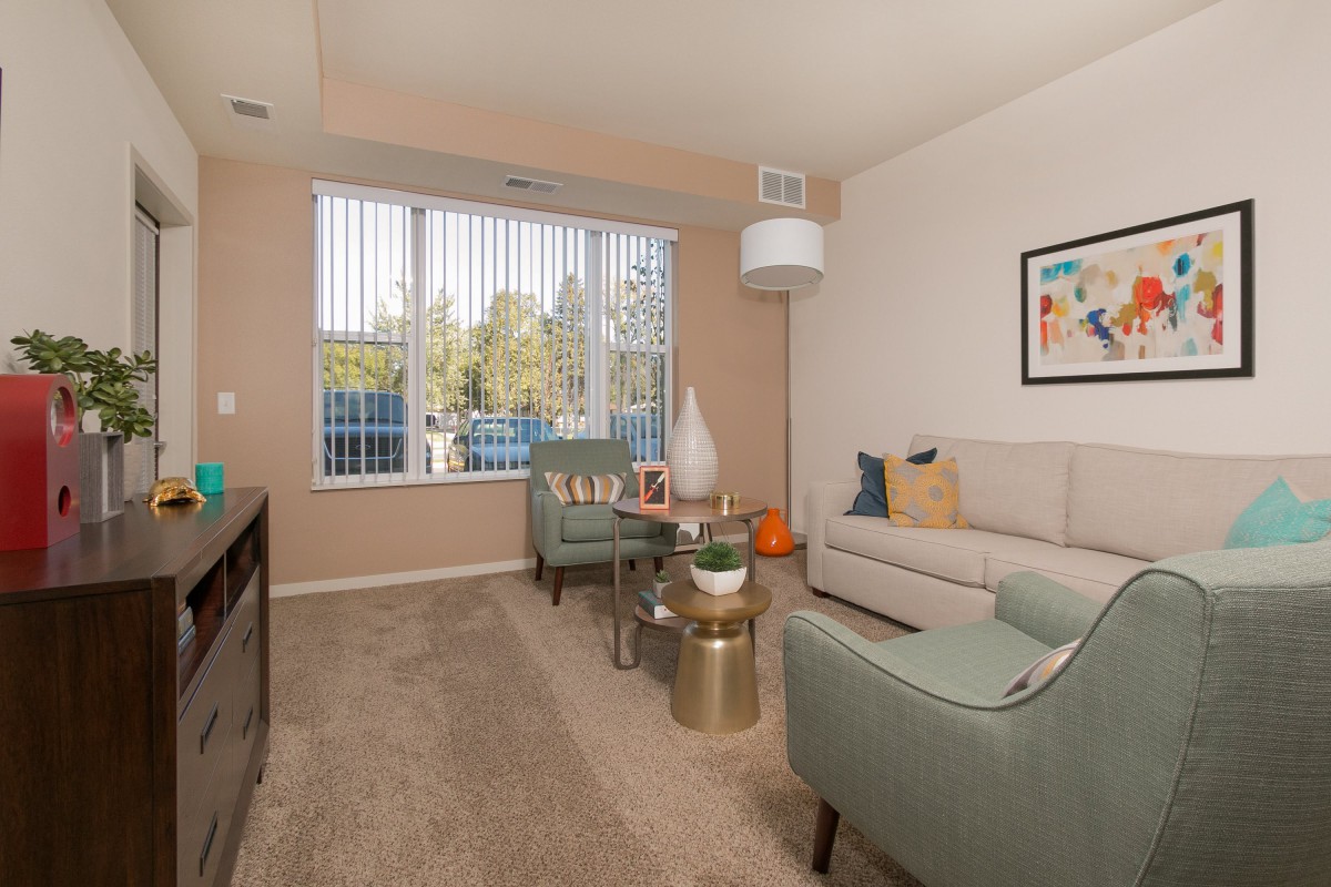 A cozy living room with modern furniture and a large window providing natural light.