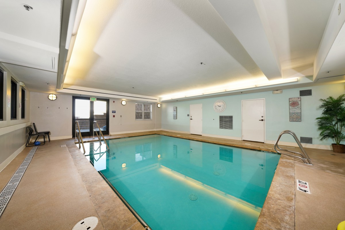 An inviting indoor swimming pool with a serene atmosphere, surrounded by clean and modern architecture.
