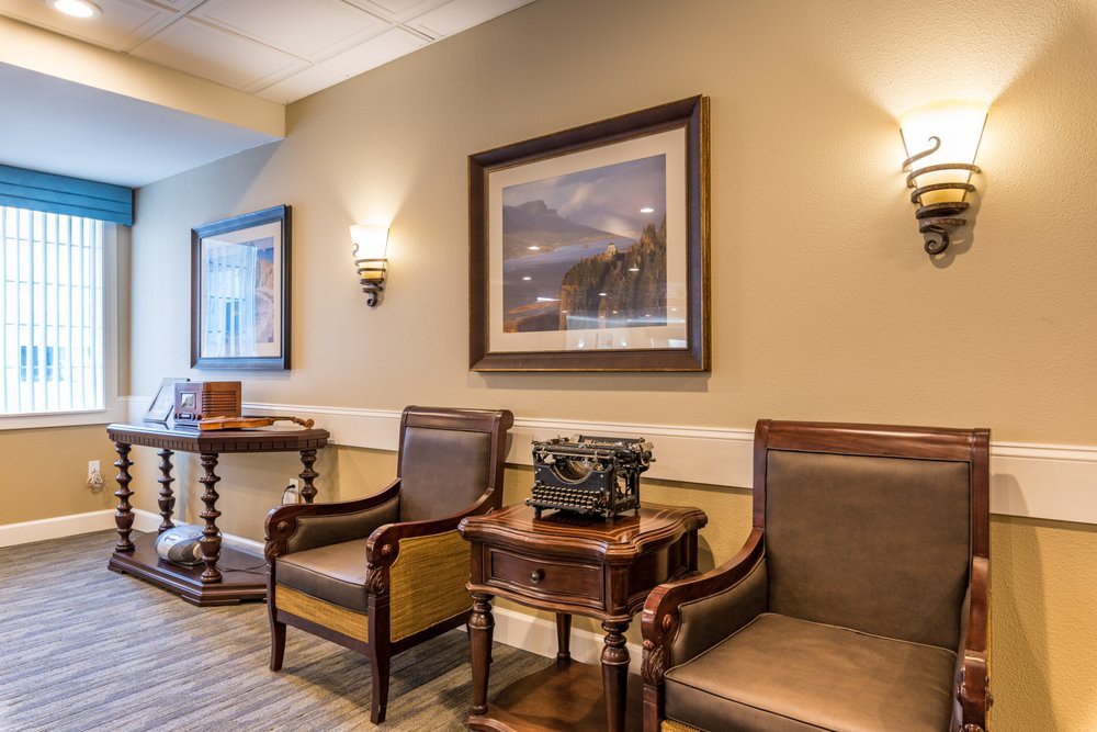 A cozy waiting area with comfortable seating, artwork on the walls, and warm lighting.