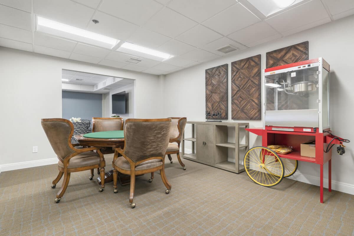 A cozy meeting room with a conference table, plush chairs, and a popcorn machine.