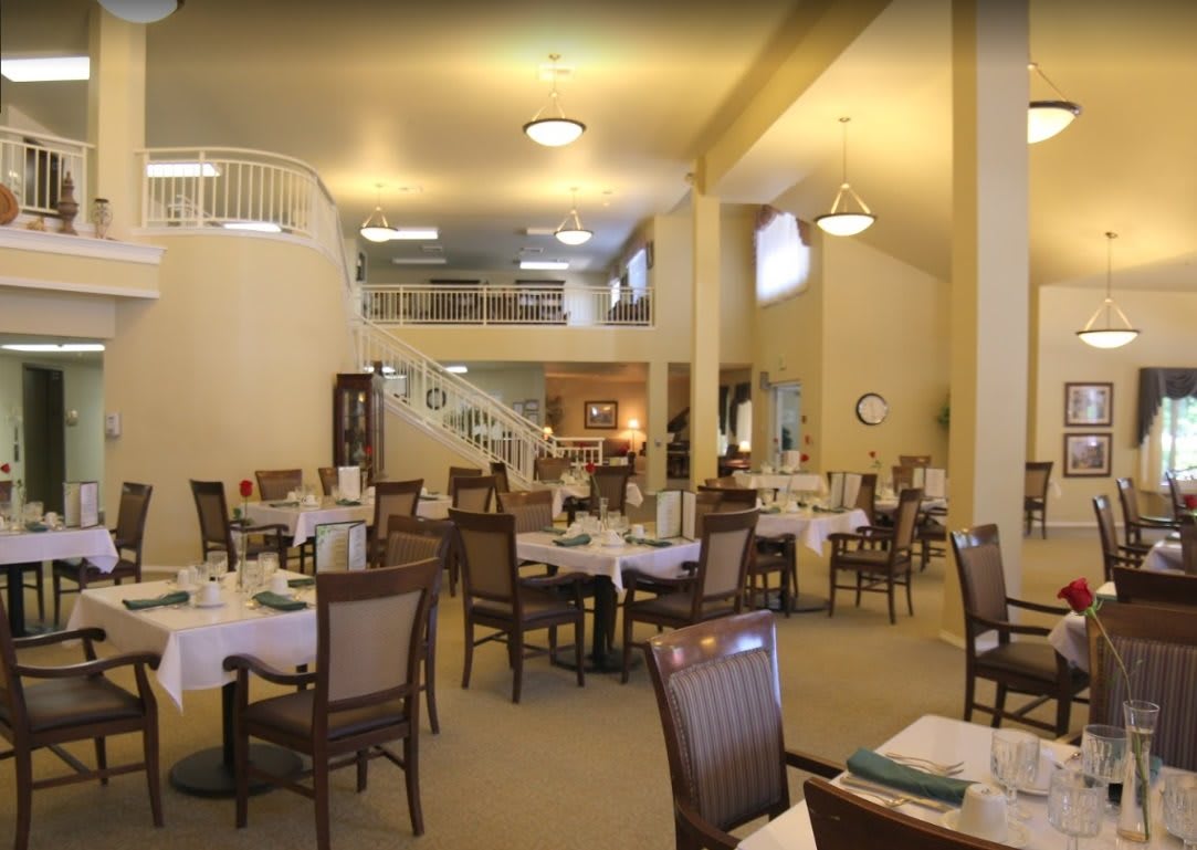 An interior view of a spacious restaurant dining area with neatly arranged tables and chairs.