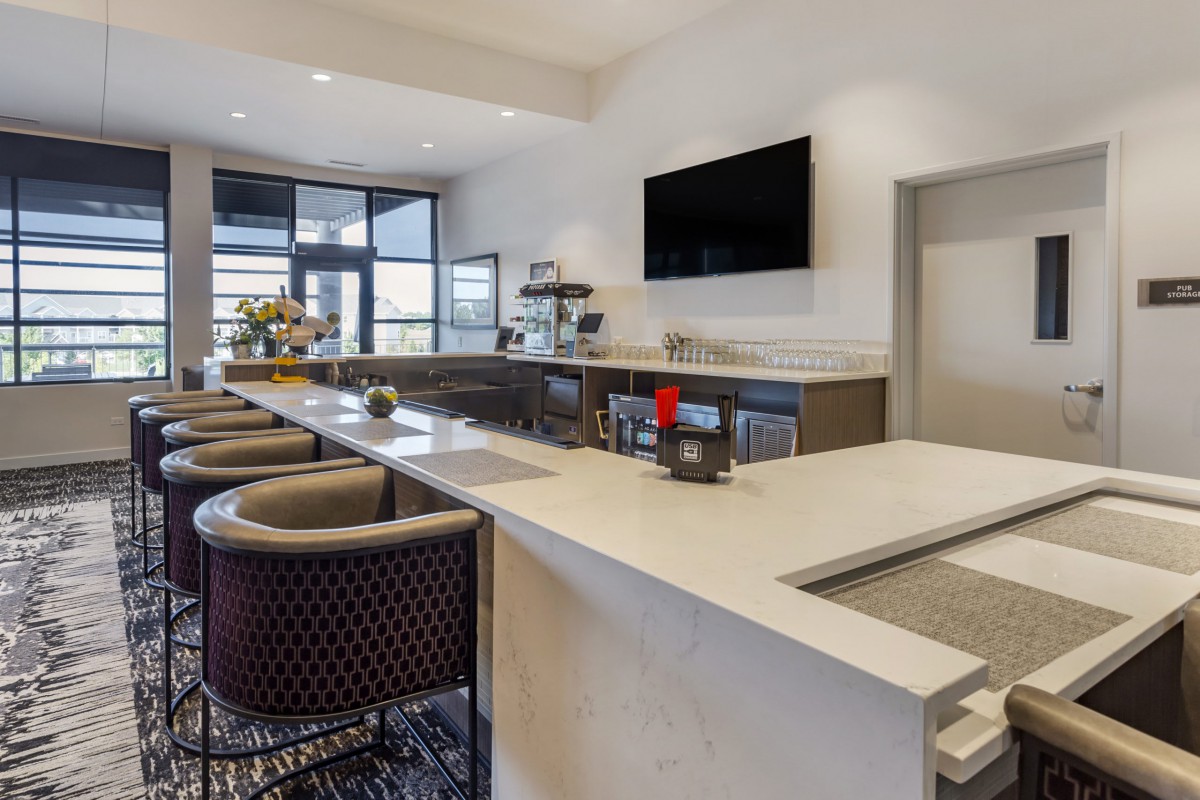 A modern bar interior with a sleek counter and comfortable seating.