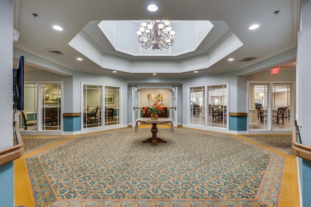 Elegant lobby interior with chandelier and central table.