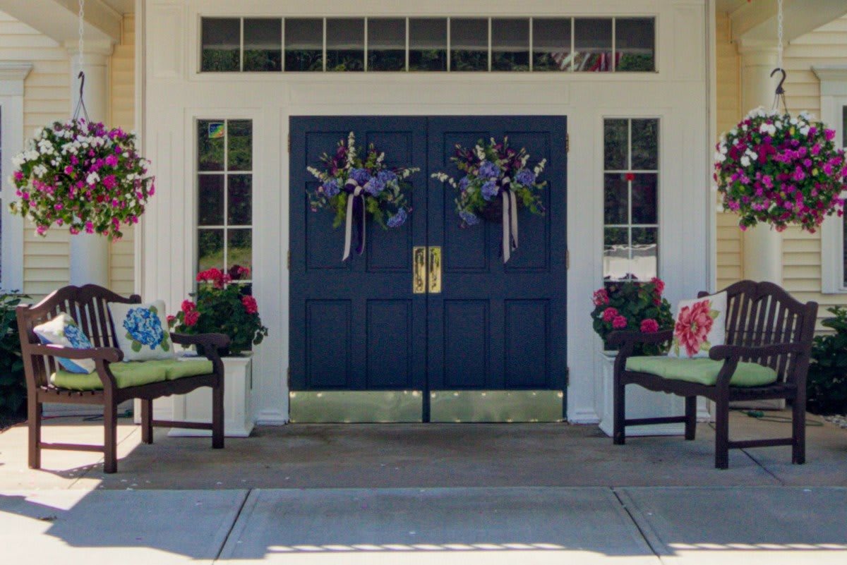 A welcoming front entrance adorned with wreaths and vibrant flowers.