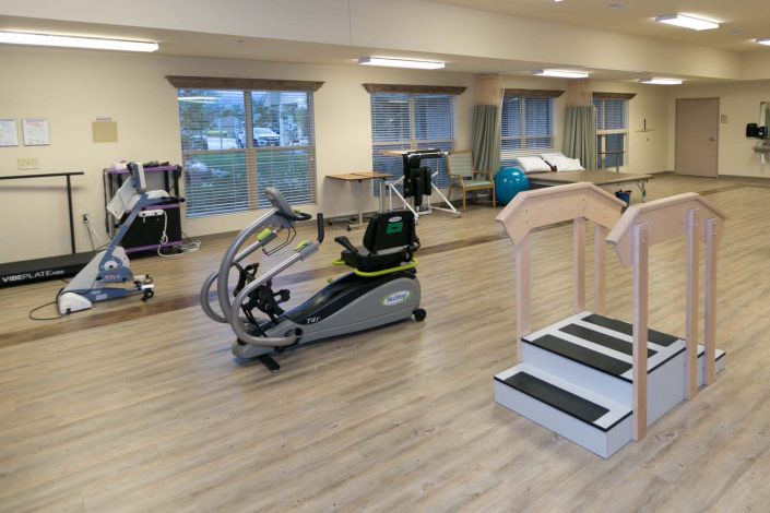 A spacious rehabilitation center featuring various exercise equipment and machines.