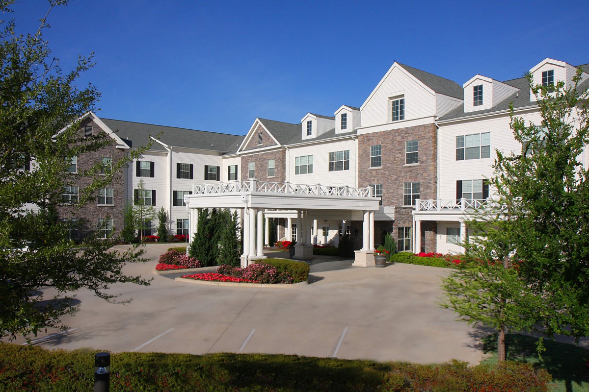 A large residential building with a landscaped entrance and driveway.