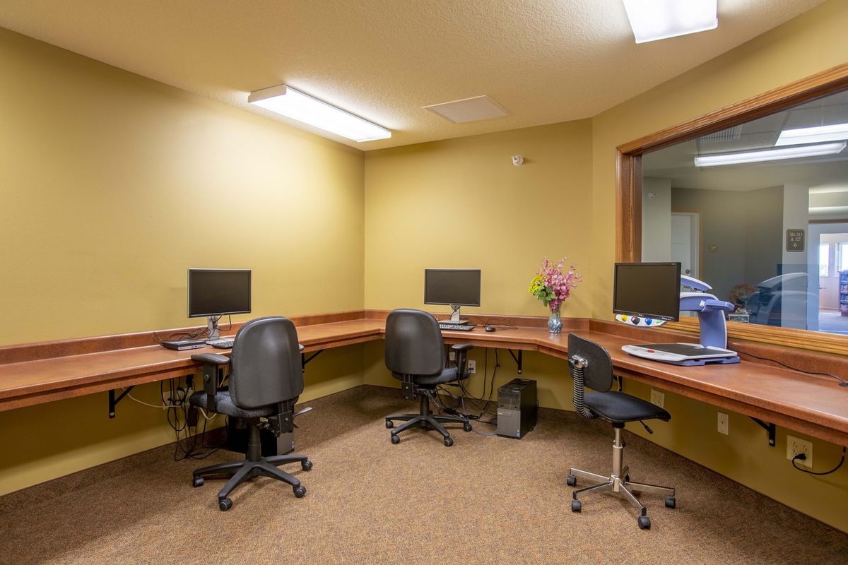 A small office space with desks, chairs, and computer monitors.