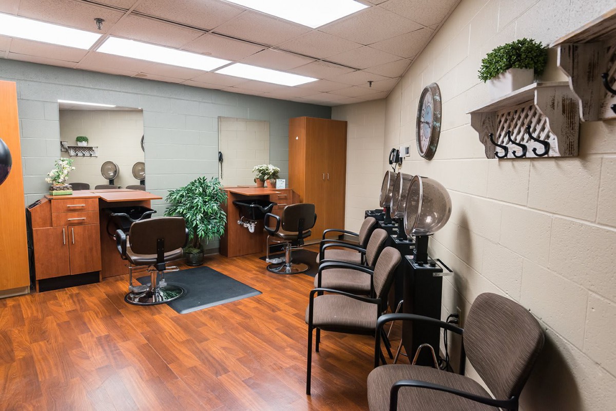 A well-lit hair salon interior with chairs and mirrors.