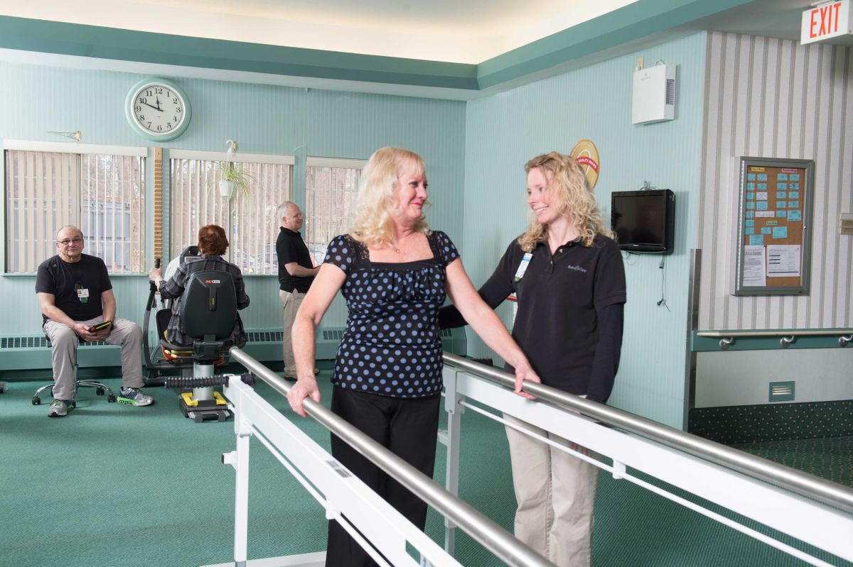 A patient undergoes physical therapy with the assistance of a healthcare professional.