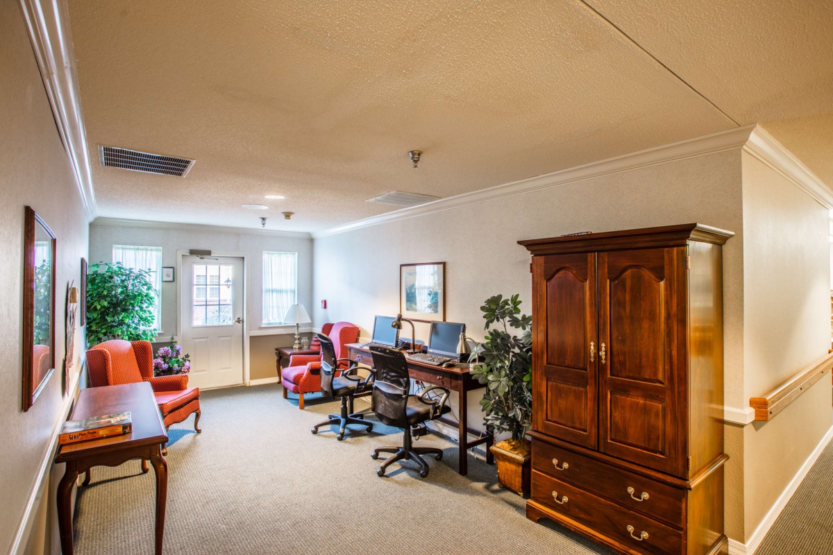A cozy office space with two desks, computers, and comfortable chairs.