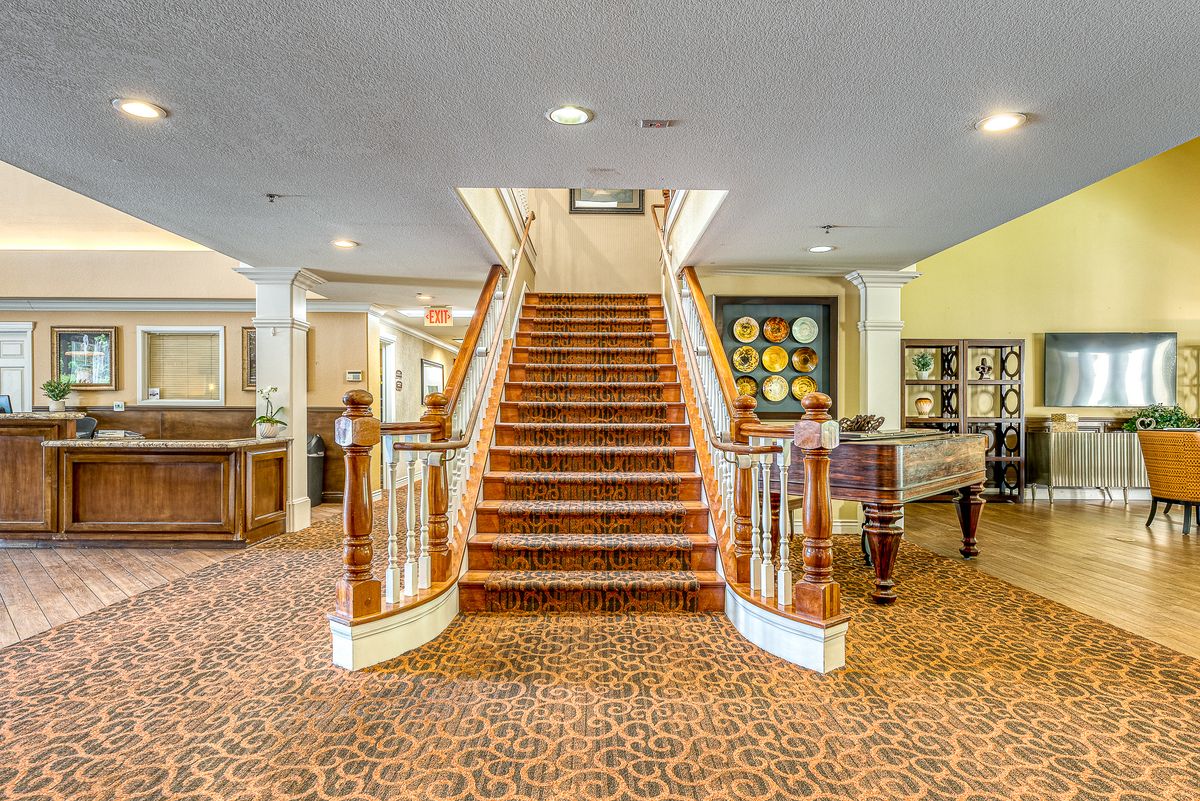 A grand interior with a central staircase and elegant decor.