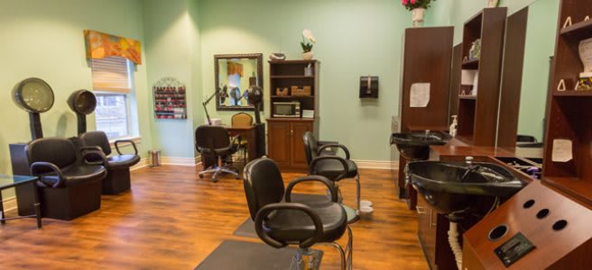A cozy hair salon interior featuring styling chairs and mirrors.