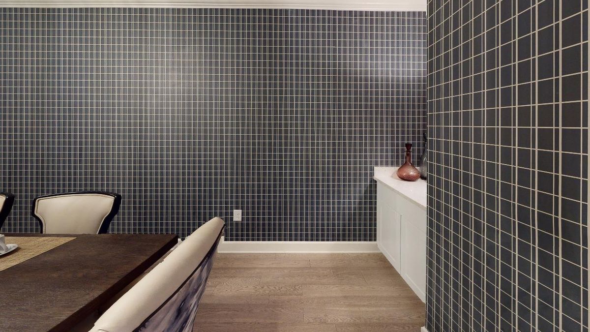 A modern room with checkered wallpaper, featuring a table and decorative vases.