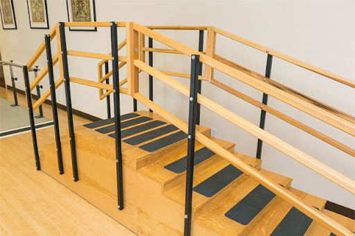 A set of stairs equipped with handrails and safety markings, designed for accessibility.
