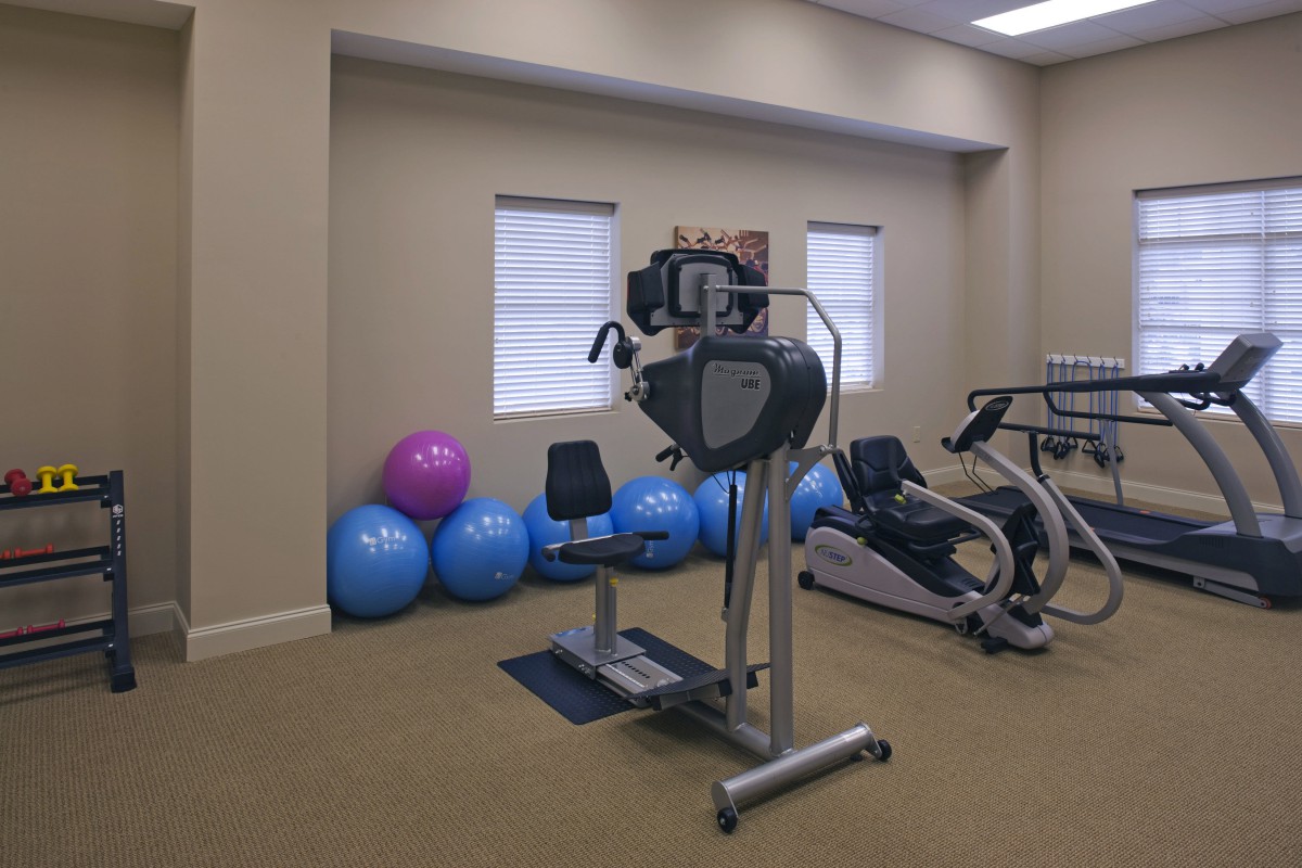 A gym room featuring various exercise equipment, including stationary bikes and exercise balls.