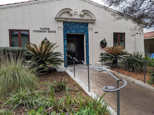 An inviting entrance to the community room, surrounded by lush greenery.