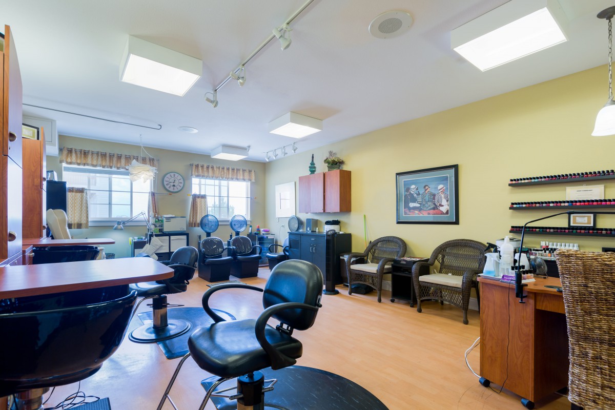 A brightly lit hair salon interior with multiple styling chairs and mirrors.