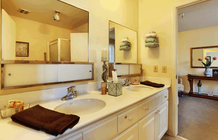 A well-organized bathroom with dual sinks, mirrors, and neatly arranged towels.