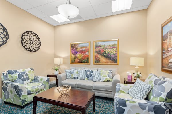 A cozy living room with comfortable sofas, decorative pillows, and colorful artwork on the walls.