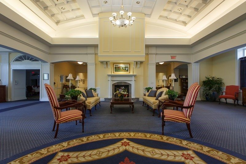 A luxurious lobby with elegant furnishings and a central fireplace.