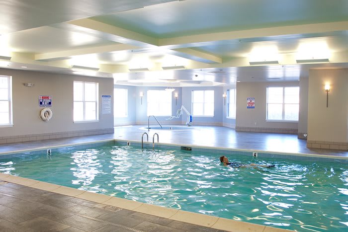 An indoor swimming pool with a person enjoying a swim.