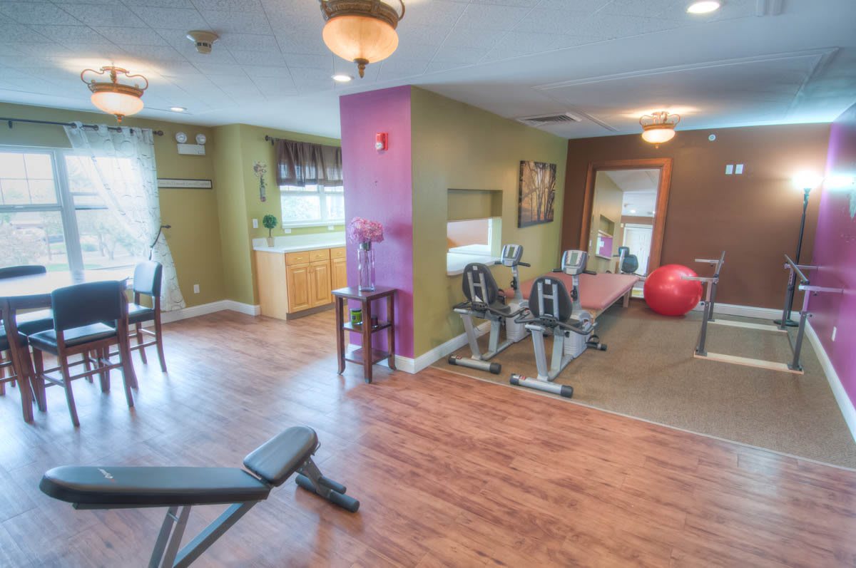 A well-lit gym space featuring exercise equipment and workout benches.