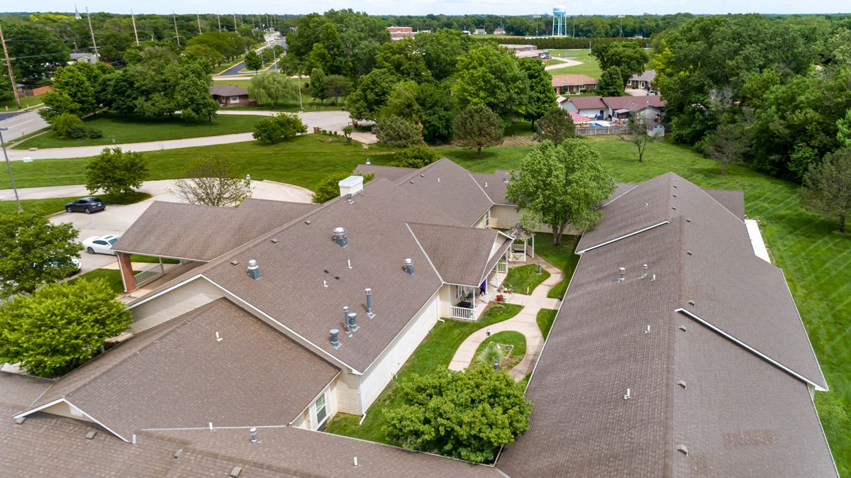 Aerial view of suburban rooftops surrounded by greenery.