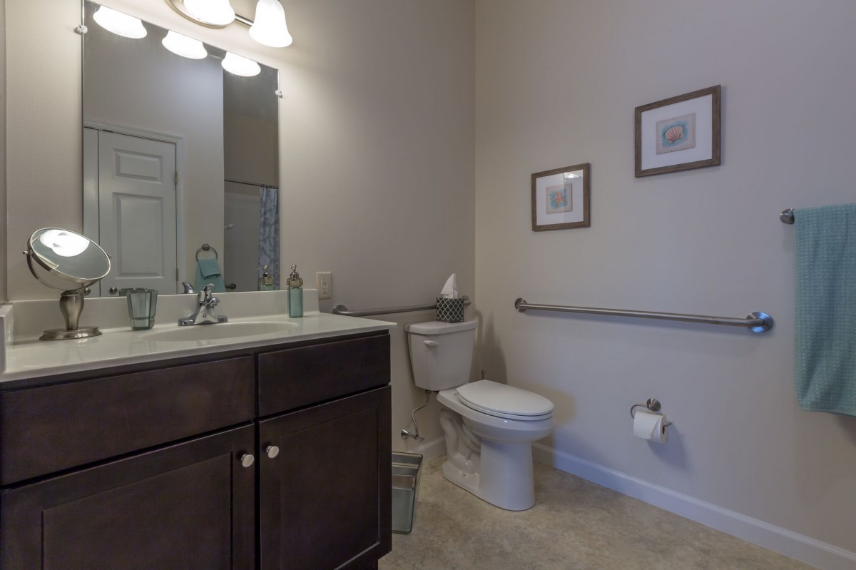 A modern bathroom with a sink, toilet, and vanity.