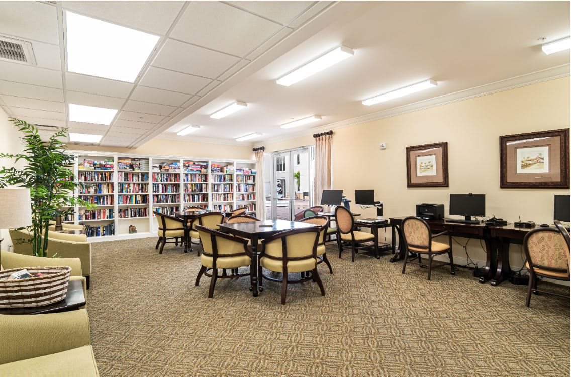 A quiet library reading room with bookshelves, computers, and seating areas.