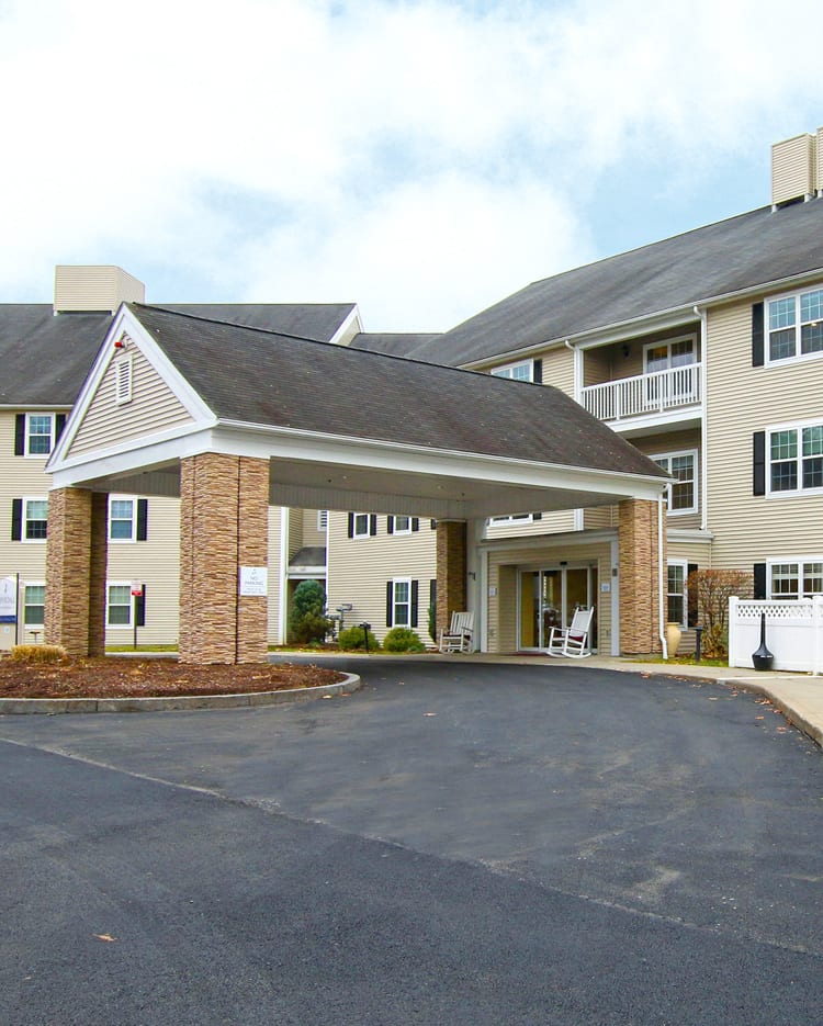 A residential building with a covered entrance and driveway.
